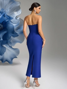 Detail view of the back of a navy strapless bandage dress with zipper and slit