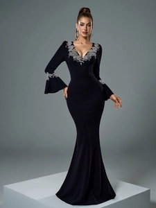 Détail de broderie florale à paillettes argentées sur robe de soirée noire à col en V