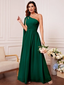Détail d'une élégante robe de soirée asymétrique vert foncé avec plis en mousseline