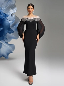 Close-up of elegant black evening gown with luxury bead tassels and sheer lantern sleeves