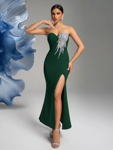 Detailed view of dark green strapless dress featuring crystal wing decor and high slit