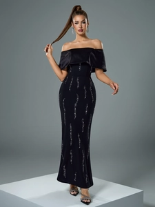 Detail of elegant off-shoulder black evening gown with shimmering silver sequin patterns