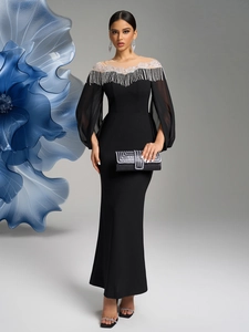 Detail of beaded fringe neckline and sheer lantern sleeves on a black evening gown