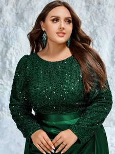 Detailed view of sequin stitching and satin waistband on a luxury dark green evening dress