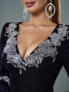 Détail de broderie florale en paillettes argentées sur robe de soirée noire