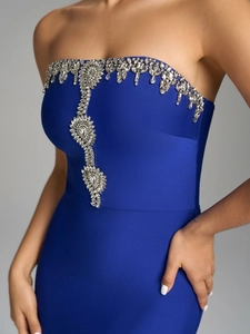 Detailed view of rhinestone embellishments on a royal blue strapless knit bandage dress