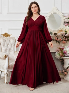 Dettaglio macro dell'abito in chiffon a pieghe bordeaux con maniche a lanterna e scollo a V