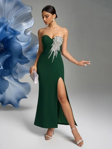 Detail of sequin feather bodice on dark green evening dress with high side slit