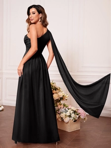 Détail d'une élégante robe de soirée noire à une épaule avec une longue cape fluide traînante