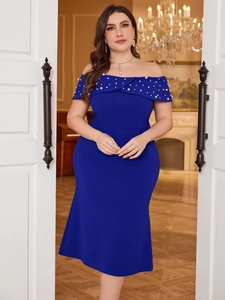 Close-up of pearl embellishments on the off-shoulder neckline of a royal blue evening gown