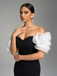 Detail of white organza floral sleeves on a black off-shoulder cocktail dress