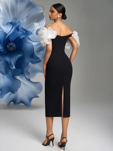 Detail of elegant off-shoulder black dress with white organza flowers and back slit design