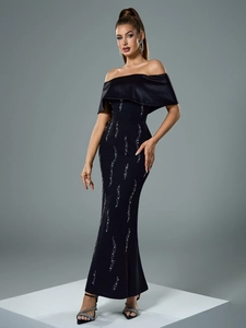 Detail of elegant off-shoulder black evening gown with shimmering silver rhinestone patterns