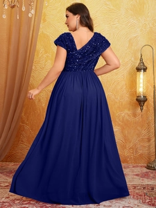 Detail of elegant sequined evening gown with deep V-back and flowing navy chiffon skirt