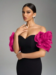 Detail of elegant off-shoulder evening dress with oversized pink pleated floral sleeves