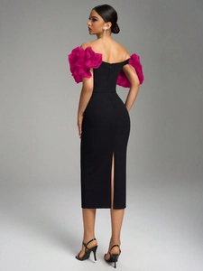 Close-up of black bodycon dress featuring pink ruffled flower sleeves and back slit detail