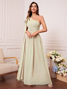 Détail d'une robe de soirée asymétrique en mousseline vert sauge avec taille plissée
