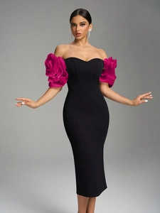 Detail of elegant off-shoulder black dress with oversized rose sculptural sleeves