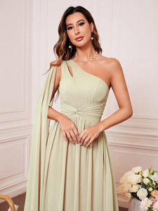 Détail d'une robe de soirée en mousseline vert sauge à une épaule avec plis élégants