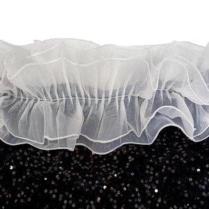 Détail de plis en organza blanc et texture de tissu en velours à paillettes noires