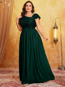 Detailed close-up of dark green sequin bodice and pleated chiffon waist on formal gown