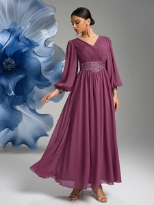 Détail du corsage plissé à col en V et de la ceinture à paillettes sur robe longue prune