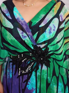 Detail of V-neck evening gown with digital watercolor print and heavy floral embroidery