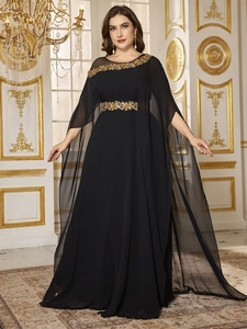 Close-up of golden embroidery and sequins on black chiffon dress neckline and waist