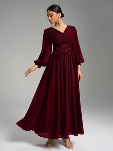 Détail du corsage en V avec plis et ceinture à paillettes scintillantes sur la robe rouge