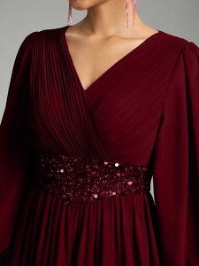 Détail du corsage plissé en V et taille pailletée sur robe de soirée en mousseline bordeaux