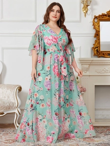 Détail d'une robe fleurie en mousseline avec col en V, manches papillon et ceinture
