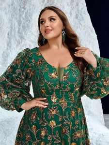 Detail of dark green evening gown featuring gold sequin floral embroidery and V-neckline