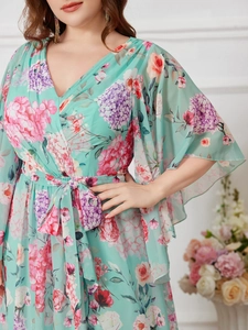Détail d'une robe en mousseline à fleurs avec col en V, manches papillon et ceinture