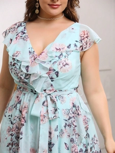 Dettaglio di un abito da sera in chiffon a fiori con scollo a V, volant e cintura