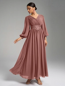 Détails du col en V plissé et de la ceinture à paillettes sur cette robe de soirée en mousseline