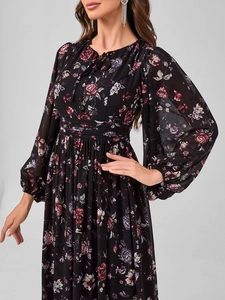 Détail de la robe longue en mousseline fleurie avec manches lanternes et taille cintrée