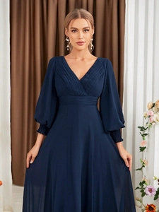 Detail of navy blue V-neck evening dress featuring elegant pleated waist and lantern sleeves
