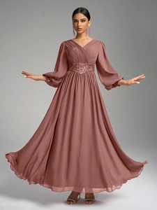 Détail d'une robe de soirée en mousseline avec col en V, corsage plissé et ceinture