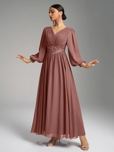 Détail d'une robe de soirée à col en V avec ceinture à paillettes et manches lanternes