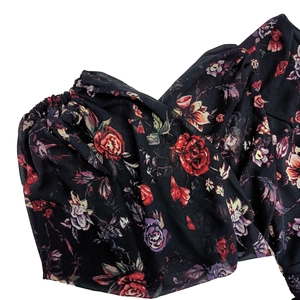 Gros plan sur tissu en mousseline à motif floral rose et détails de poignets élastiques
