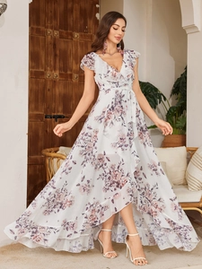 Dettaglio dello scollo a V a balze e della fantasia floreale su un abito bianco chic