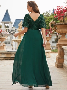 Detail of deep green sequined back with deep V-cut and flowing chiffon floor-length skirt