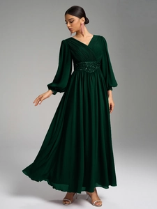 Détails du corsage plissé en V et ceinture à paillettes sur la robe en mousseline verte