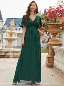 Detailed view of dark green sequin bodice and flowing chiffon skirt on a V-neck dress
