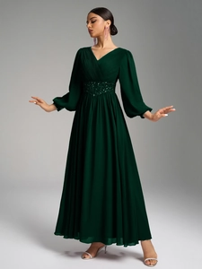 Détail de robe de soirée en mousseline à col en V avec corsage plissé et taille pailletée
