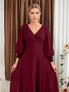 Detail of V-neck pleated bodice and lantern sleeves on burgundy evening gown