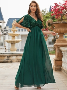 Detail of elegant emerald green evening dress with sequin bodice and flutter split sleeves