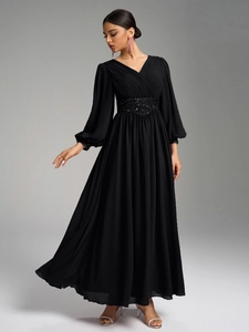 Détail des plis du col en V et de la taille à paillettes noires sur robe longue en mousseline