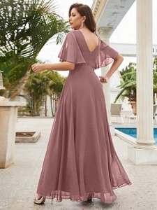 Détail de la robe de soirée en mousseline rose poudré avec col en V et volants
