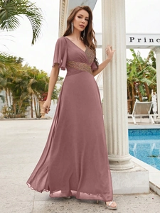 Détail d'une robe de soirée élégante en mousseline avec col en V et ceinture à paillettes